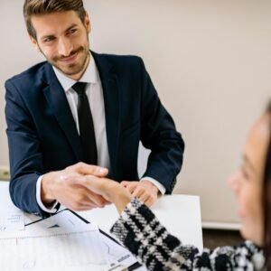 Professional businessmen shaking hands in an office environment, focused on teamwork and agreement.