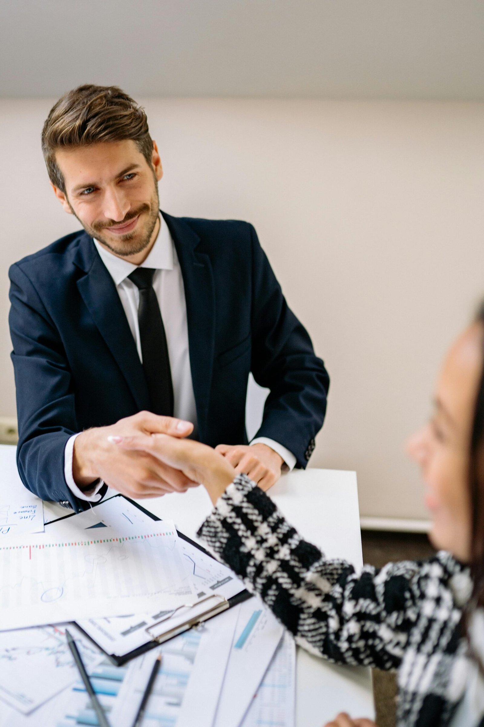 Professional businessmen shaking hands in an office environment, focused on teamwork and agreement.
